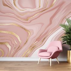 a pink chair sitting in front of a wall with gold paint on it and a potted plant