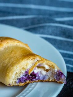 a close up of a pastry on a plate with a blueberry filling in it