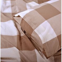 an unmade bed with brown and white checkered sheets