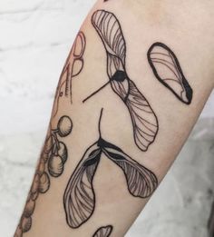 a woman's arm with tattoos on it, including an image of flowers and leaves