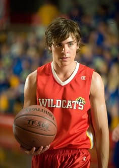 a young man holding a basketball in his right hand