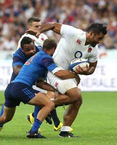 a rugby player is being tackled by two other players