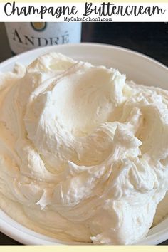 a white plate topped with whipped cream next to a bottle of champagne buttercream