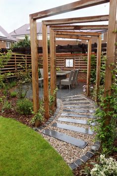 an outdoor patio with stone walkway and wooden pergolan