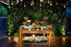 a table topped with lots of food and flowers on top of a tiled floor covered in greenery