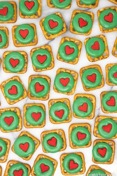 green and red heart shaped cookies are on a white tablecloth with hearts in the middle