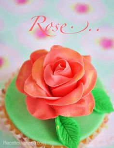 there is a cupcake decorated with a rose on the top and green icing