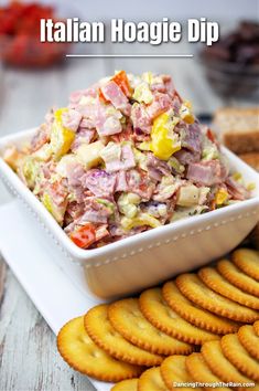 a white bowl filled with salad next to crackers