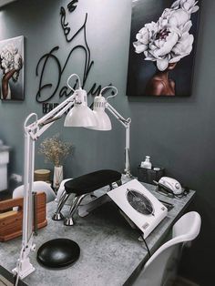 a desk with a chair, lamp and pictures on the wall