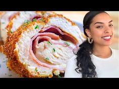 a woman standing in front of a large roll with meat and cheese on it's side