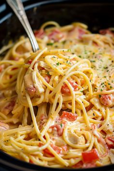 a close up of a pasta dish in a crock pot with chicken and tomatoes