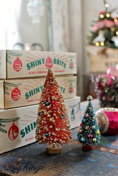 three small christmas trees sitting on top of boxes