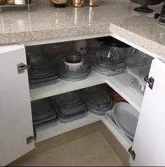 an open cabinet in a kitchen filled with dishes