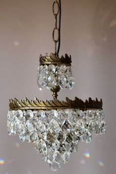 a chandelier hanging from the ceiling with lots of crystal beads on it's sides