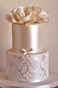 a three tiered cake with white flowers on top