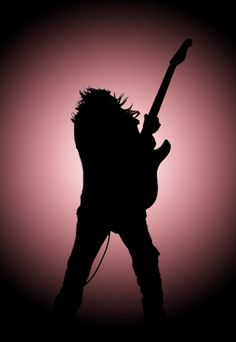 the silhouette of an electric guitar player in front of a pink sky with light coming from behind