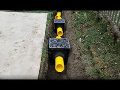 three yellow pipes laying on top of each other in the ground next to a sidewalk