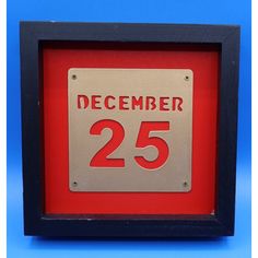 a red and black framed sign that reads december 25