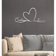 a living room with a couch, pillows and wall art that says love is in the air