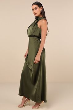 The Lulus Distinctive Charm Olive Green Satin Asymmetrical Maxi Dress is ready to party with the best (and most stylish) of them! Ultra-sleek woven satin shapes this chic dress that has a trendy mock neckline and a blousy, asymmetrical bodice with gathering. The fitted waist tops a figure-skimming, A-line maxi skirt. Top button closures secure atop a keyhole-style cutout at the back. Hidden back zipper/clasp. Fit: This garment fits true to size. Length: Floor length. Size medium measures 60.5" from shoulder to hem. Bust: Great for any cup size. Waist: Fitted - very fitted at natural waist. Hip: Loosely Fitted. Undergarments: May be worn with a strapless bra, adhesive bra, petals, or no bra. Fabric: Fabric has no stretch. Lined. Shell: 100% Polyester. Lining: 97% Polyester, 3% Spandex. Hand Satin Floor Length Dress, Army Green Dress Outfit, Olive Green Satin Dress, Asymmetrical Gown, Olive Bridesmaid Dresses, Green Dress Outfit, Green Satin Dress, Asymmetrical Maxi Dress, Army Green Dress