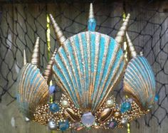 a blue and gold shell chandelier hanging from a net