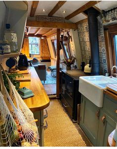 a kitchen with an oven, sink and window in the back ground is covered by a hammock