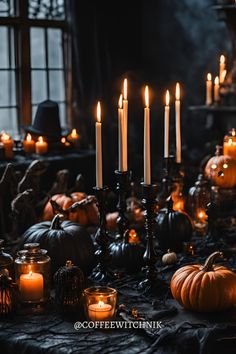 a table topped with lots of candles and pumpkins