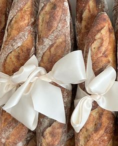 many loaves of bread wrapped in white ribbon and tied with a bow on top