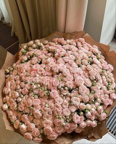 a large bouquet of pink roses sitting on top of a table