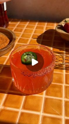 a bowl filled with red liquid sitting on top of a tiled counter next to two plates