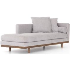 a white couch with two pillows on it and a wooden frame around the armrests