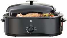 an electric slow cooker with the lid open and food in it's center