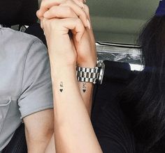 two people sitting in a car, one holding the other's hand with both hands