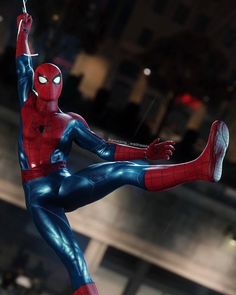 a spider - man statue is posed in front of a cityscape