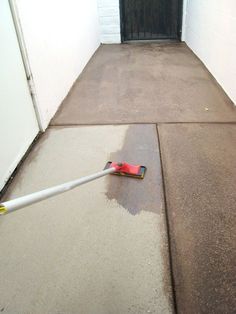 a red and white mop laying on the ground next to a door with a black handle