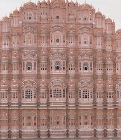 a large building made out of red bricks with windows and balconies on top