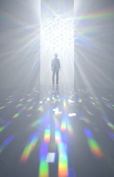 a man standing in front of a white door with bright light coming from it's center