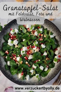 a salad with spinach, feta and pomegranate in a bowl