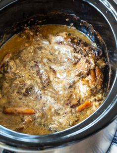 a slow cooker filled with meat and vegetables