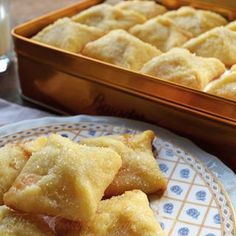 small pastries on a plate next to a glass of milk and a metal pan