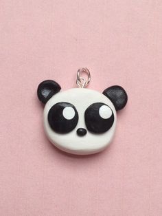 a panda bear keychain on a pink background