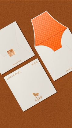 two envelopes with orange and white designs on them