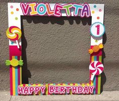 a birthday photo frame decorated with candy and lollipops on the side of a building