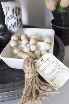 some white mushrooms are sitting in a bowl on a table with a sign that says home