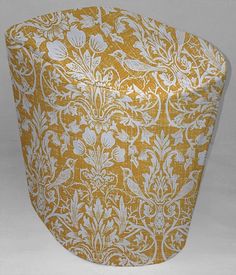 a large yellow and white vase sitting on top of a table