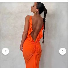 a woman in an orange dress with her back to the camera