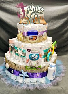 a multi layer diaper cake with baby items on top