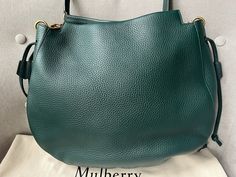 Overview Mulberry Iris Hobo in Mulberry Green Heavy Grain Leather with pale gold hardware. This large hobo has only a slight slouch and is perfect for those who prefer larger sized bags for day to day wear. Casual and chic, this shade of green is stunning. Featuring the signature keystone lock and drawstring ties to enhance the bag's natural tactility. Can be carried over shoulder using the long detachable strap. Features Mulberry green heavy grain leather Pale gold components Keystone lock feature with magnetic popper closure Green shoulder strap Two side ties of adjustable volume and space One main compartment and interior slip pocket Foil embossed signature on front panel Suede lined interior Condition New Excellent condition with light signs of wear. There are only . Excellent with min Mulberry Iris, Prada Nylon Bag, School Bags For Kids, Pale Gold, Carry All Bag, Louis Vuitton Shoulder Bag, To Day, Small Crossbody Bag, Chanel Black