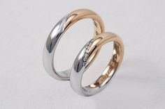 two gold and silver wedding rings with diamonds on each side, set against a white background