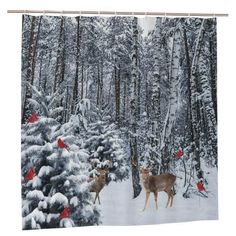 two deer standing in the snow next to trees with red birds perched on top of them